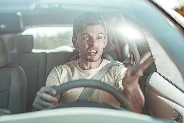 Wütender brünetter Mann benutzt während der Fahrt üble Ausdrücke — Stockfoto