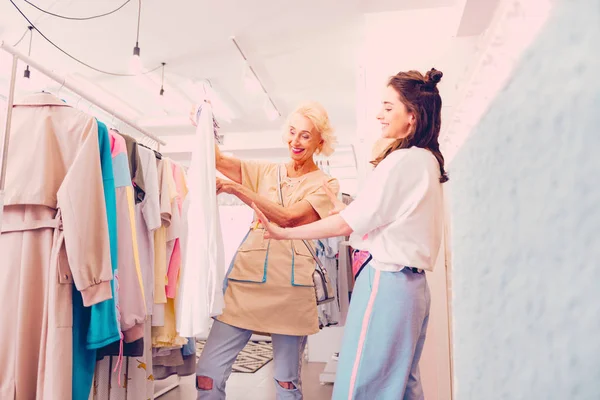 Mujeres eligiendo ropa nueva en la boutique juntas — Foto de Stock