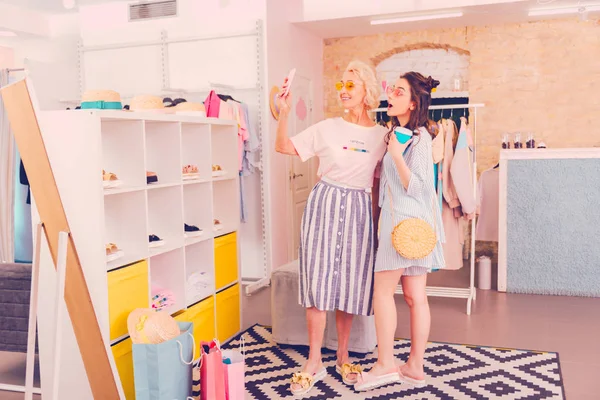 Мать и дочь делают смешное селфи в бутике — стоковое фото