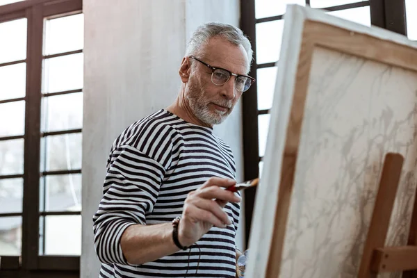 Artist wearing bracelet having painting brush in his hands — Stock Photo, Image