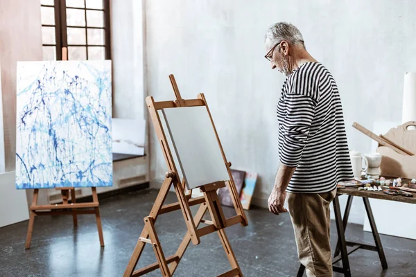 Artist standing in front of white canvas having no inspiration — Stock Photo, Image