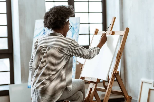 Artista con gafas sosteniendo pincel de pintura y dibujo — Foto de Stock