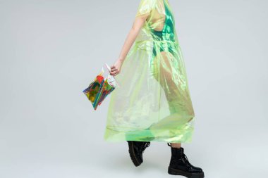 Plastik ceket giyen çizme ve Plastik çanta tutarak model yürüyüş