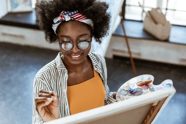 Rayonnant artiste avec beau maquillage souriant tout en peignant — Photo