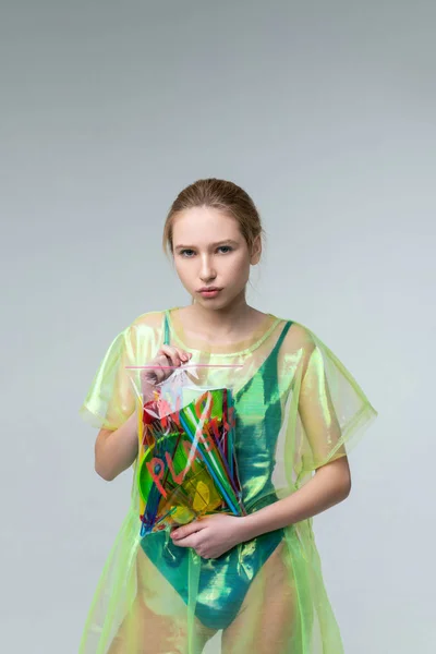 Skinny model showing sad serious face posing in plastic clothes — Stock Photo, Image