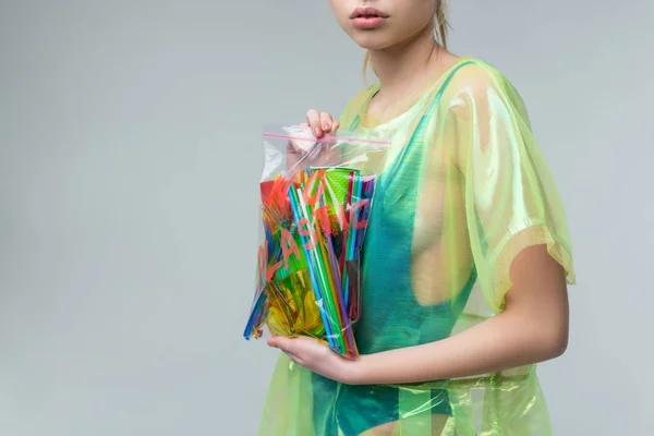 Närbild av modell hållande påse med plast muggar och halmstrån — Stockfoto