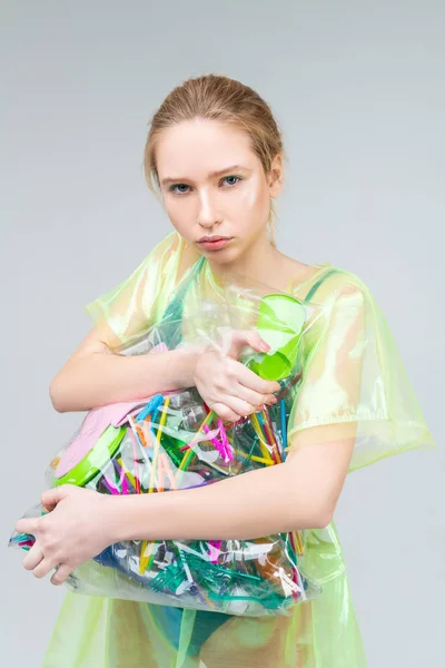 Serious responsible model holding huge bag with plastic items — Stock Photo, Image