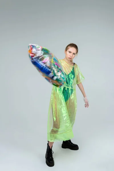 Angry model pretending to throw plastic bag with many items — Stock Photo, Image