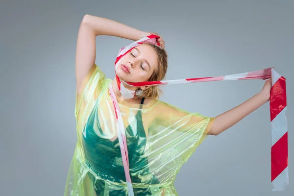 Skinny modell klädd i plast kläder stängning ögon samtidigt poserar — Stockfoto