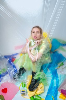 Ekoloji hareketi için poz sırasında plastik levha yakın oturan model