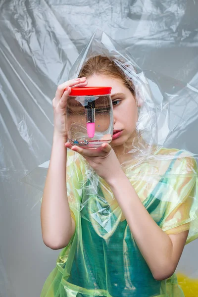 Modell poserar för ekologi kampanj som håller glas kan med läppglans — Stockfoto