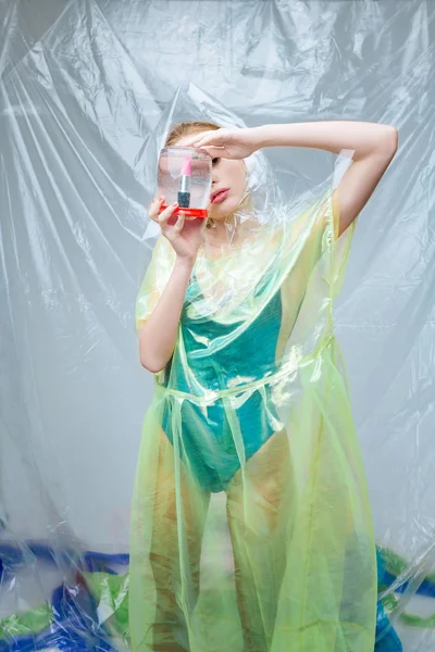 Model giyen olmayan doğal giyim tutan dudak parlatıcısı ile olabilir