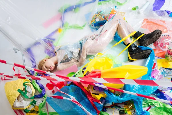 Model closing eyes while posing on floor wrapped into plastic — Stock Photo, Image