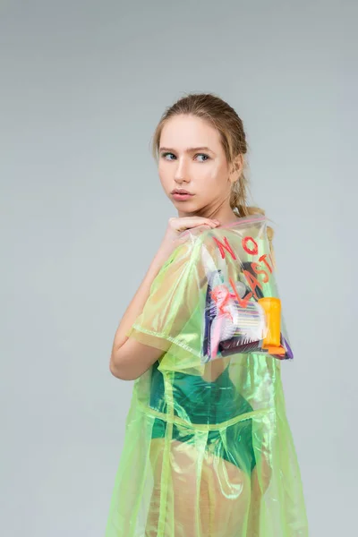 Mujer rubia seria cuidando bolsa transparente llena de plástico —  Fotos de Stock