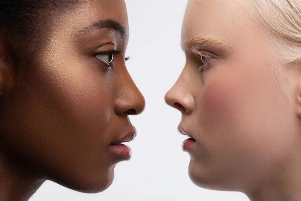 Två unga kvinnor med olika hudfärg tittar in i ögonen — Stockfoto