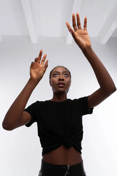 Skinny African-American model wearing short black t-shirt