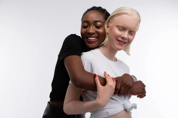 Αφροαμερικάνικη γυναίκα αγκαλιάζει τον καλύτερό της φίλο με λευκό δέρμα — Φωτογραφία Αρχείου