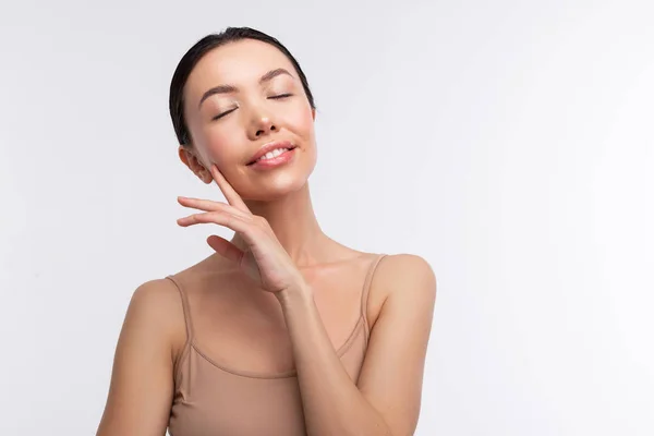 Mujer morena vistiendo camisola beige cerrando los ojos —  Fotos de Stock