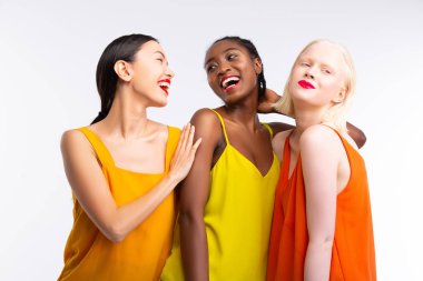Farklı cilt rengine sahip kadınlar parlak renkli giysiler giyiyor