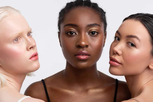 African-American woman standing between women with light skin — Stock Photo, Image