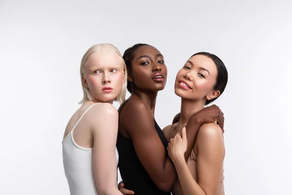 Три женщины с разным цветом кожи позируют для проблемы разнообразия — стоковое фото