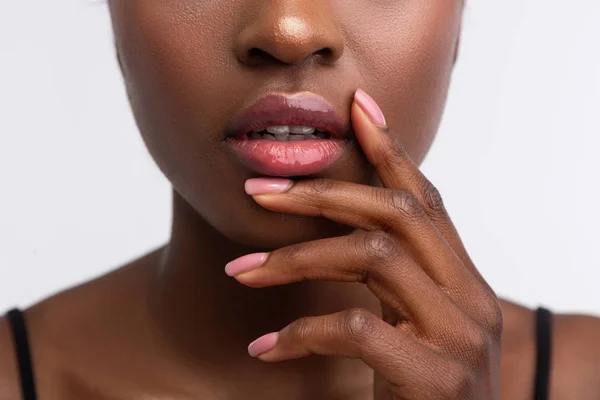 Africano-americano mulher tocando lábios com brilho labial brilhante — Fotografia de Stock