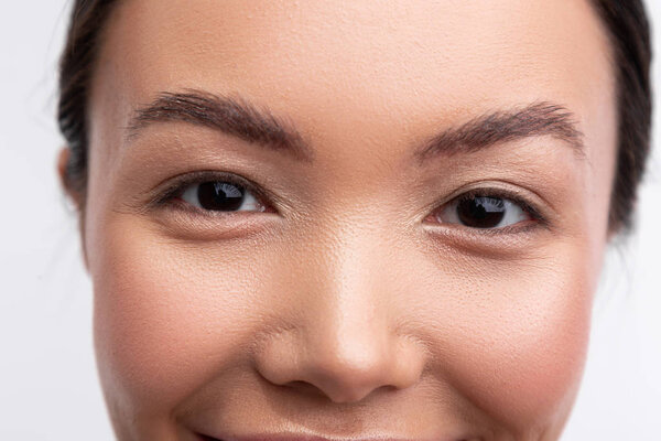 Dark-eyed woman with black eyebrows having natural makeup