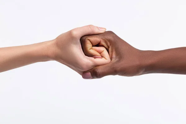 Dos mujeres con diferente color de piel estrechando las manos — Foto de Stock