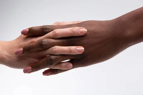 Mujer afroamericana estrechando la mano de un amigo con piel blanca — Foto de Stock