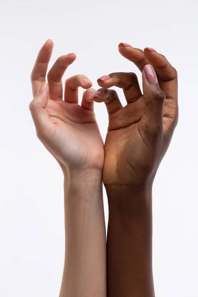 Mujeres con piel blanca y negra sosteniendo sus manos juntas — Foto de Stock