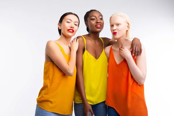 Mujeres con piel diferente que usan jeans y blusas coloridas —  Fotos de Stock