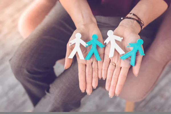 Close-up shot of human stick figures being put on palms.