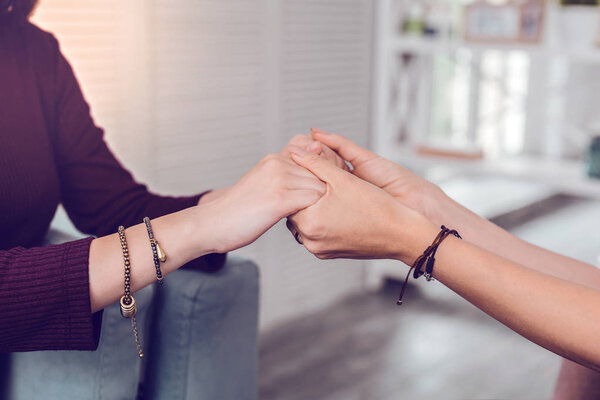 Close-up shot of two female delicate hands being hold