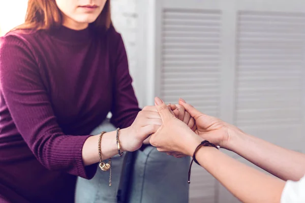 Two women supporting encouraging and holding hands of each other — Stock Photo, Image