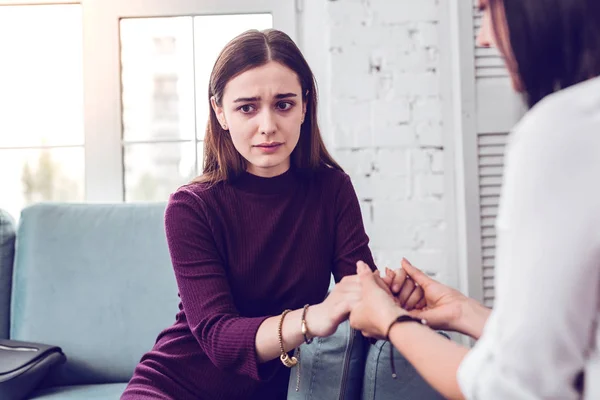 Upset crying scared attractive lady being comforted by a therapist