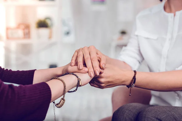 Close-up shot of a female psychologist and patient holding hands. — Stock Photo, Image
