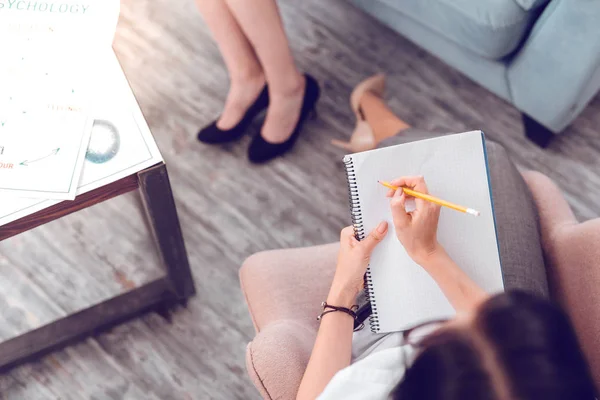 Above close-up photo of therapist writing down treatment interview thesis — Stock Photo, Image