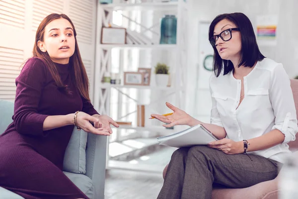 Beautiful attractive young-adult lady discussing relationship problems with a psychologist. — Stock Photo, Image