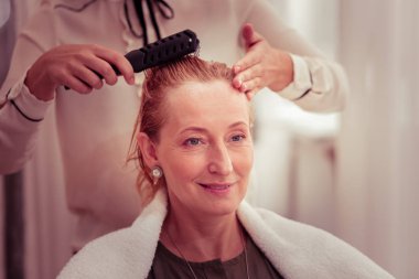 Memnun sarışın kadın onun yansıması bakarak