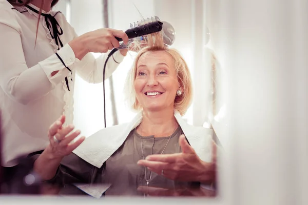 Cheerful elderly female communicating with her master — Stock Photo, Image