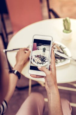 Güzel genç kadın onun salata bir fotoğraf çekmek