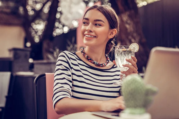 Радостная милая женщина держит стакан с напитком — стоковое фото