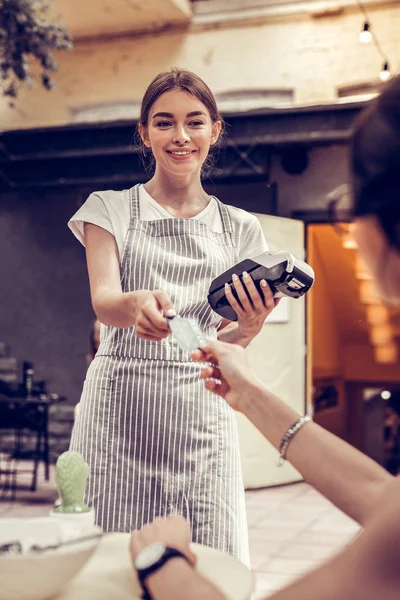 Vrolijke positieve serveerster die een bank Terminal vasthoudt — Stockfoto