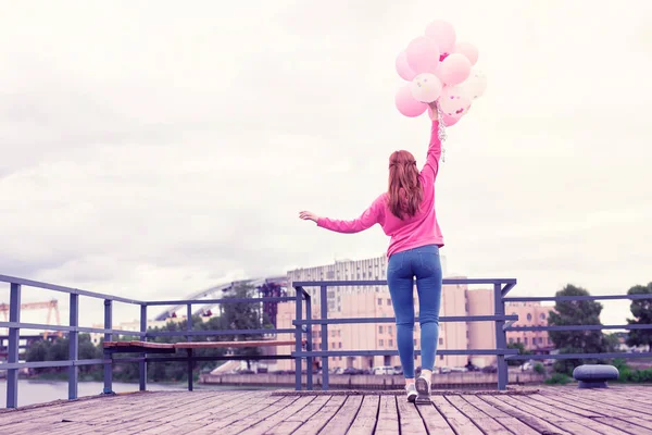 Mageres Ingwermädchen in rosa Kapuzenpulli mit Luftballons — Stockfoto