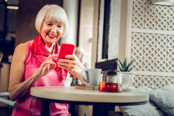 Joyeuse femme âgée utilisant son nouveau smartphone — Photo