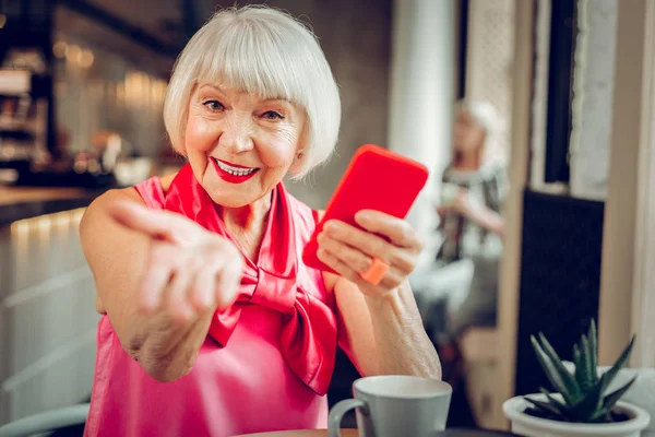 Happy positive senior woman smiling to you