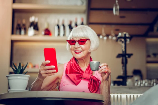 Zachwycona miła w wieku kobieta trzyma filiżankę kawy — Zdjęcie stockowe