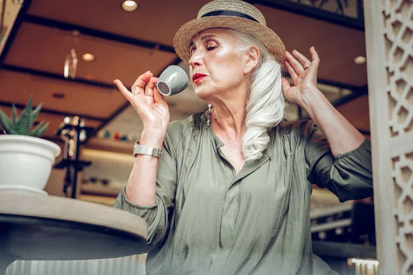 Милая, стильная, зрелая женщина пьет вкусный эспрессо — стоковое фото