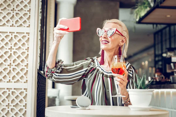 Délicieuse femme âgée tenant un verre avec cocktail — Photo