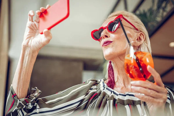 Trevlig trevlig kvinna tittar på sin smartphone — Stockfoto